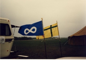 Le drapeau fransaskois et le drapeau métis flottant côte à côte lors de la 6e Fête fransaskoise à Batoche en 1985