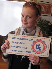 A young woman proudly displays a poster