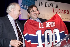 Andrew Molson, propriétaire des Canadiens de Montréal, remet un chandail au directeur du Devoir pour souligner les 100 ans d'existence du journal