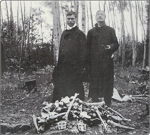 Father Arthur Béliveau and Judge Louis-Arthur Prud'homme standing behind bones discovered during the Société historique de Saint-Boniface expedition to Fort Saint-Charles in 1908