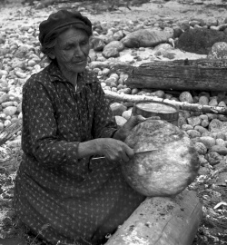 Mme Ignace Picard, 78 ans, Montagnaise de Bersimis, faisant cuire la banique à Manicouagan, 1934, 