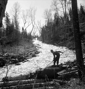 A log driver prevents a log jam in a waterway, Gatineau, 1942.