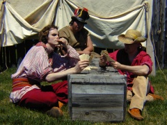 A group of interpreters in the role of voyageurs playing cards, Fort William.